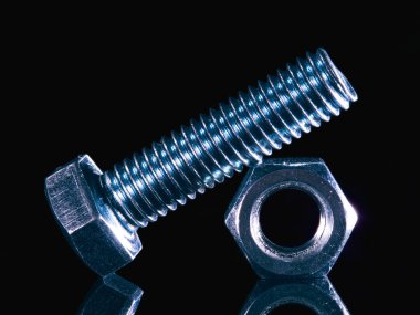 Iron bolt and nut on black background with reflexion