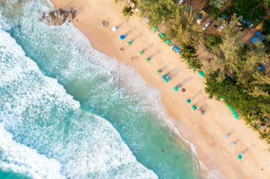 Mutlu insanlardan oluşan insansız hava aracı kalabalığı Phuket, Tayland 'da gün batımında tropikal plajda dinleniyor. Güzel Phuket plajı Andaman Denizi' nde ünlü bir turizm merkezidir. Yaz tatili konsepti