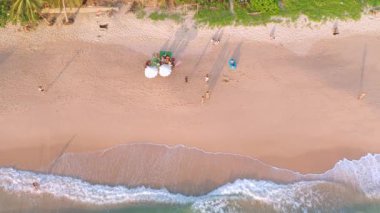 Phuket, Tayland 'da gün batımı olan tropikal plajdaki insansız hava aracı kalabalığı Andaman Denizi' nde ünlü bir turizm merkezidir. Sahilde oynayan mutlu insanlar.