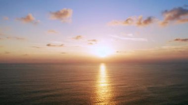 4K Günbatımı gökyüzü ile güzel tropikal plaj. Güzel Phuket plajı, Andaman Denizi yaz konseptinde ünlü bir turizm merkezidir. Denizin üzerinde günbatımı olan gerçek bir drone manzaralı tropikal plaj