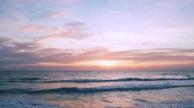 4K Günbatımı gökyüzü ile güzel tropikal plaj. Güzel Phuket plajı, Andaman Denizi yaz konseptinde ünlü bir turizm merkezidir. Denizin üzerinde günbatımı olan gerçek bir drone manzaralı tropikal plaj