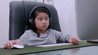 Ev konseptinden 4K öğren. Asyalı kız öğrenciler covid-19 salgınından dolayı internetten sanal internet dersleri alıyorlar. Kız öğrenci evde bilgisayarla internetten öğreniyor