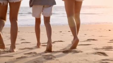 Ağır çekimde koşan aile tropik günbatımı plajının tadını çıkarır. Anne ve çocuklar plajda birlikte koşuyorlar. Tatilden memnunlar. Tatil seyahati kavramı.