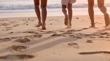 Ağır çekimde koşan aile tropik günbatımı plajının tadını çıkarır. Anne ve çocuklar plajda birlikte koşuyorlar. Tatilden memnunlar. Tatil seyahati kavramı.