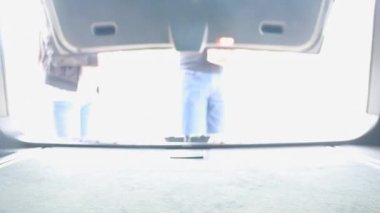 4K erkek ve kadın bir çift, alışveriş arabasında, meyve ve sebzelerle dolu alışveriş çantasıyla ve arabada kağıt poşetlerle birlikte yürüyorlar. İçeriden çekilmiş Aile yaşam tarzı konsepti