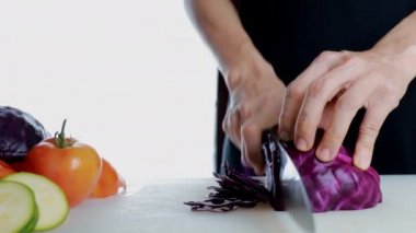 4K Kadın Eli kesme tahtasında taze kırmızı lahana kesiyor. Dişi el, çiğ kırmızı lahana dilimliyor. Kesme tahtasındaki bıçakla küçük bir sürgüye. sağlıklı gıda konsepti.