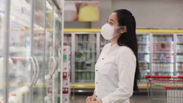 亚洲妇女戴着防护面罩 在超级市场百货商店推着购物车 去杂货店买点吃的Covid 19之后的新常态家庭概念 — 图库视频影像