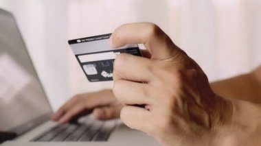 4K, yakın çekim, elinde kredi kartı olan adam. Kredi kartıyla online alışveriş. İnternet üzerinden alışveriş yaparken erkek eller kredi kartını tutuyor. Elektronik ödeme çevrimiçi. İş konsepti.