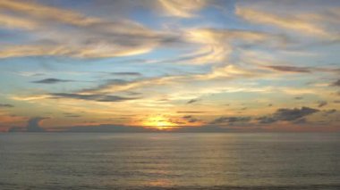 4K UHD hava görüntüsü İHA görüntüsü denizden yansıyan bulutlar, gün batımı ve güneş ışığı ile karaya çıkmak için denizin bir aşağı bir geri hareket ediyor. Deniz aşırı güzel gün batımı