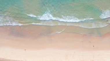 4K Aerial insansız hava aracı, Phuket, Tayland 'da günbatımı olan tropikal plajdaki insanların en iyi görüntüsü Andaman Denizi' nde ünlü bir turizm merkezidir. Sahilde oynayan mutlu insanlar.