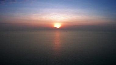 4K UHD Hava Görüntüsü Drone görüntüsü denizden yansıyan bulutlar ve güneş ışığıyla birlikte gün batımına doğru ilerliyor. Deniz aşırı güzel gün batımı