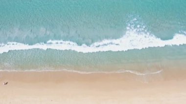 4K Aerial insansız hava aracı, Phuket, Tayland 'da günbatımı olan tropikal plajdaki insanların en iyi görüntüsü Andaman Denizi' nde ünlü bir turizm merkezidir. Sahilde oynayan mutlu insanlar.