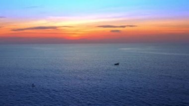 4K UHD Hava Görüntüsü Drone görüntüsü denizden yansıyan bulutlar ve güneş ışığıyla birlikte gün batımına doğru ilerliyor. Deniz aşırı güzel gün batımı