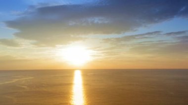 4K UHD Hava Görüntüsü Drone görüntüsü denizden yansıyan bulutlar ve güneş ışığıyla birlikte gün batımına doğru ilerliyor. Deniz aşırı güzel gün batımı