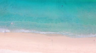 4K Aerial insansız hava aracı, Phuket, Tayland 'da günbatımı olan tropikal plajdaki insanların en iyi görüntüsü Andaman Denizi' nde ünlü bir turizm merkezidir. Sahilde oynayan mutlu insanlar.