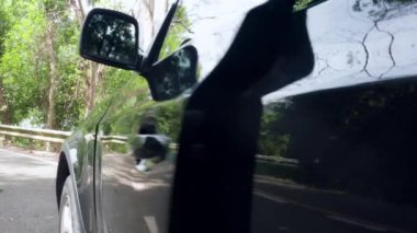 Kadının elini arabanın kapağını kapat. Kadın arabaya biner ve kapıyı kapatır. Kadın aracın içinde oturuyor. El kızı araba açar ve kuaförde oturur..