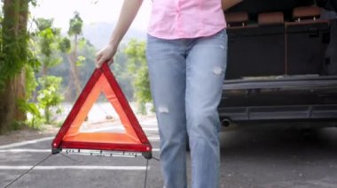 Trafik kazası geçiren kadın banliyö yoluna kırmızı üçgen işareti yerleştiriyor. Genç kadınlar kırmızı tringle uyarısı alıyor ve yan yola çıkıyorlar. Ulaşım kavramı