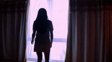 4K kamera hareket ediyor, arkadan bakıyor, valiz açan, dantelli mutlu seyahat eden kadınlar lüks villa otelinde dikiliyor ve pencereden tropikal deniz manzarasının keyfini çıkarıyorlar. Tatil seyahati