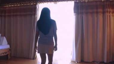 4K kamera hareket ediyor, arkadan bakıyor, valiz açan, dantelli mutlu seyahat eden kadınlar lüks villa otelinde dikiliyor ve pencereden tropikal deniz manzarasının keyfini çıkarıyorlar. Tatil seyahati