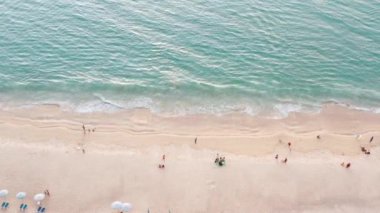 Phuket, Tayland 'da gün batımı olan tropikal plajdaki insansız hava aracı kalabalığı Andaman Denizi' nde ünlü bir turizm merkezidir. Sahilde oynayan mutlu insanlar.