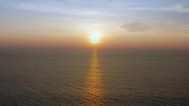 4K UHD Hava Görüntüsü Drone görüntüsü denizden günbatımına doğru bulutlar ve güneş ışığı ile yansıyor. Deniz aşırı güzel gün batımı