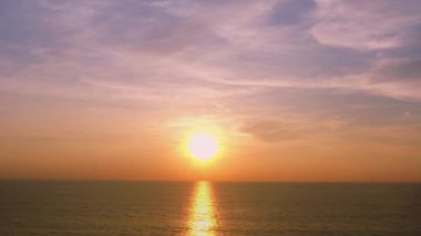 Günbatımı gökyüzü ile güzel tropikal plaj. Güzel Phuket plajı, Andaman Denizi yaz konseptinde ünlü bir turizm merkezidir. Denizin üzerinde günbatımı olan gerçek bir drone manzaralı tropikal plaj