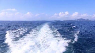 Köpüklü yüzeyi olan deniz suyu tekne yolculuğu. Gemi yolunu takip et. Mavi kaynayan okyanus suyu. Mavi denizde okyanus dalgası izleri var. Tatlı su arka planı.