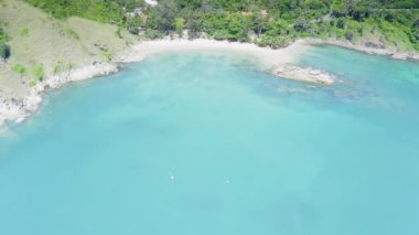 Phuket, Tayland 'da gün batımı olan tropikal plajdaki insansız hava aracı kalabalığı Andaman Denizi' nde ünlü bir turizm merkezidir. Sahilde oynayan mutlu insanlar.