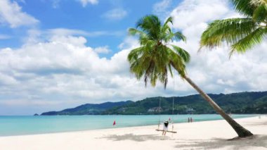 4K Phuket, Tayland. Plaj cenneti ve beyaz gömlekli kız. Kadınlar salıncakta sallanır, hindistan cevizi palmiyesinin altında, güzel tropik sahilde, beyaz kumsalda..