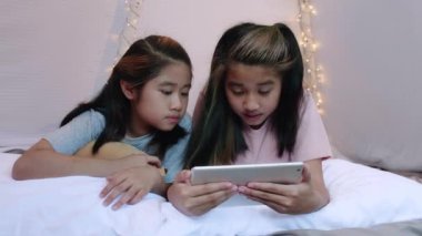 4K Kid, yatak çarşafı çadırında birlikte portatif oyun oynuyor. İki kız kardeş mutlu bir şekilde eğleniyor ve birlikte oyun oynuyorlar. Kardeş kız evdeki çarşaf çadırında oyun oynuyor.