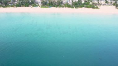 4K Aerial insansız hava aracı, Phuket, Tayland 'da günbatımı olan tropikal plajdaki insanların en iyi görüntüsü Andaman Denizi' nde ünlü bir turizm merkezidir. Sahilde oynayan mutlu insanlar.
