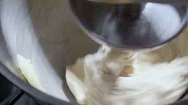 4K, un karıştırma makinesi kullanarak ekmek hamuru üretme işlemini kapat. Makine ekmek hamuru yoğurur. Ev yapımı çiğ ekmek ve küçük makine. Yiyecek konsepti.