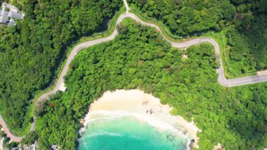 4K Areal İHA 'sı Phuket Thailand kıyı yolunun kıvrımlarına tepeden bakıyor. Phuket kıyı şeridi üzerinde güzel bir deniz aracı, ünlü bir turizm merkezidir. Plajın çevresindeki en iyi trafik yolu.