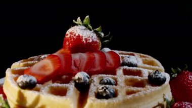 4K. Pasta şefinin eli taze pişmiş waffle 'ların üzerine yabanmersini ve ahududu koyar. Fırından taze ahududu ve böğürtlen ile süslenmiş..