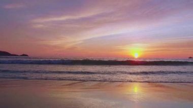 4K Günbatımı gökyüzü ile güzel tropikal plaj. Güzel Phuket plajı, Andaman Denizi yaz konseptinde ünlü bir turizm merkezidir. Denizin üzerinde günbatımı olan gerçek bir drone manzaralı tropikal plaj