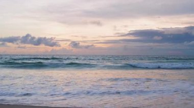 4K Günbatımı gökyüzü ile güzel tropikal plaj. Güzel Phuket plajı, Andaman Denizi yaz konseptinde ünlü bir turizm merkezidir. Denizin üzerinde günbatımı olan gerçek bir drone manzaralı tropikal plaj