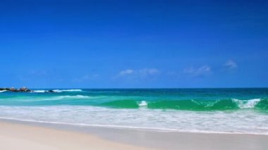 4K Mavi gökyüzü ve bulutları olan güzel tropikal plaj. Dalgaların boş plajı vurduğu tropik bir sahil. Andaman Phuket plajı Tayland. Güzel yaz gününde deniz kumu ve gökyüzü. Tatil özgürlüğü.