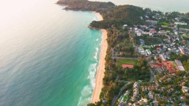 4K Aerial insansız hava aracı, Phuket, Tayland 'da günbatımı olan tropikal plajdaki insanların en iyi görüntüsü Andaman Denizi' nde ünlü bir turizm merkezidir. Sahilde oynayan mutlu insanlar.
