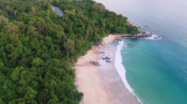 4K Aerial insansız hava aracı, Phuket, Tayland 'da günbatımı olan tropikal plajdaki insanların en iyi görüntüsü Andaman Denizi' nde ünlü bir turizm merkezidir. Sahilde oynayan mutlu insanlar.
