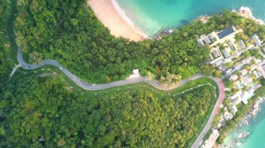 4K Areal İHA 'sı Phuket Thailand kıyı yolunun kıvrımlarına tepeden bakıyor. Phuket kıyı şeridi üzerinde güzel bir deniz aracı, ünlü bir turizm merkezidir. Plajın çevresindeki en iyi trafik yolu.