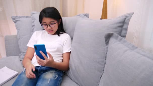 快乐的兄弟姐妹孩子们坐在客厅的沙发上和父母一起用手机聊天 微笑的姐姐用智能手机给可爱的妹妹打电话 和家人聊天 生活方式 — 图库视频影像