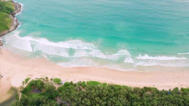 4K Aerial insansız hava aracı, Phuket, Tayland 'da günbatımı olan tropikal plajdaki insanların en iyi görüntüsü Andaman Denizi' nde ünlü bir turizm merkezidir. Sahilde oynayan mutlu insanlar.