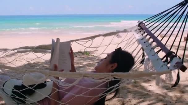Phuket泰国 日落时分 亚洲年轻女子在海滩边的吊床上看书 放松身心 年轻迷人的女性在吊床上荡秋千 暑假假期 — 图库视频影像