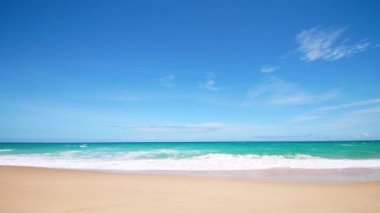 4K Mavi gökyüzü ve bulutları olan güzel tropikal plaj. Dalgaların boş plajı vurduğu tropik bir sahil. Andaman Phuket plajı Tayland. Güzel yaz gününde deniz kumu ve gökyüzü. Tatil özgürlüğü.