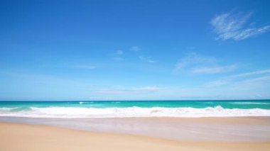 4K Mavi gökyüzü ve bulutları olan güzel tropikal plaj. Dalgaların boş plajı vurduğu tropik bir sahil. Andaman Phuket plajı Tayland. Güzel yaz gününde deniz kumu ve gökyüzü. Tatil özgürlüğü.