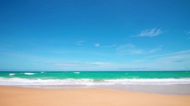 4K Mavi gökyüzü ve bulutları olan güzel tropikal plaj. Dalgaların boş plajı vurduğu tropik bir sahil. Andaman Phuket plajı Tayland. Güzel yaz gününde deniz kumu ve gökyüzü. Tatil özgürlüğü.