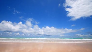 4K Mavi gökyüzü ve bulutları olan güzel tropikal plaj. Dalgaların boş plajı vurduğu tropik bir sahil. Andaman Phuket plajı Tayland. Güzel yaz gününde deniz kumu ve gökyüzü. Tatil özgürlüğü.