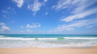 4K Mavi gökyüzü ve bulutları olan güzel tropikal plaj. Dalgaların boş plajı vurduğu tropik bir sahil. Andaman Phuket plajı Tayland. Güzel yaz gününde deniz kumu ve gökyüzü. Tatil özgürlüğü.
