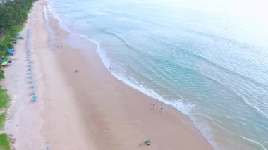 4K Aerial insansız hava aracı, Phuket, Tayland 'da günbatımı olan tropikal plajdaki insanların en iyi görüntüsü Andaman Denizi' nde ünlü bir turizm merkezidir. Sahilde oynayan mutlu insanlar.