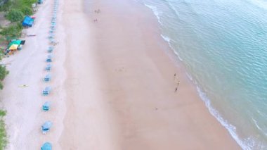 4K Aerial insansız hava aracı, Phuket, Tayland 'da günbatımı olan tropikal plajdaki insanların en iyi görüntüsü Andaman Denizi' nde ünlü bir turizm merkezidir. Sahilde oynayan mutlu insanlar.
